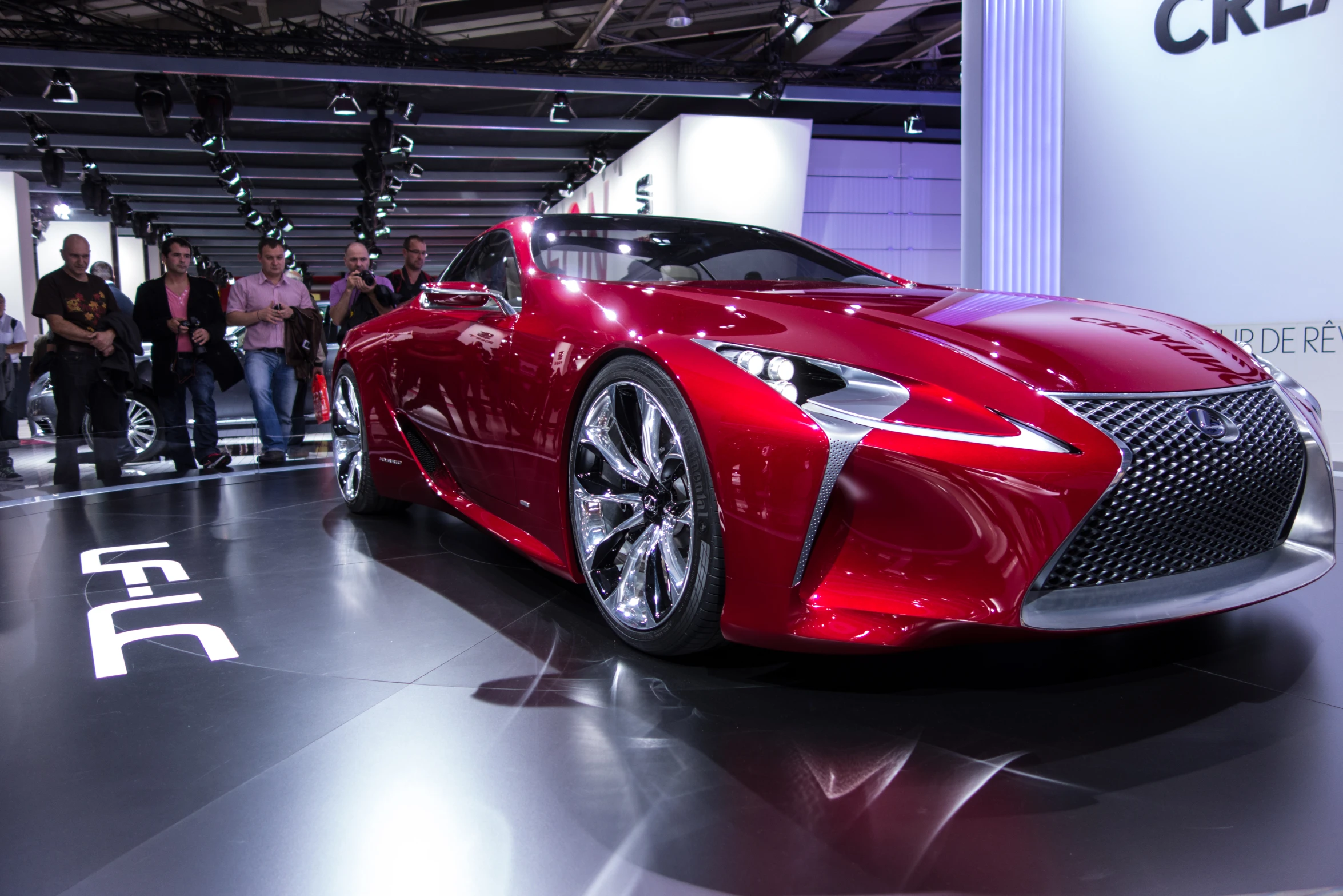 a red car sitting on top of a floor in a garage