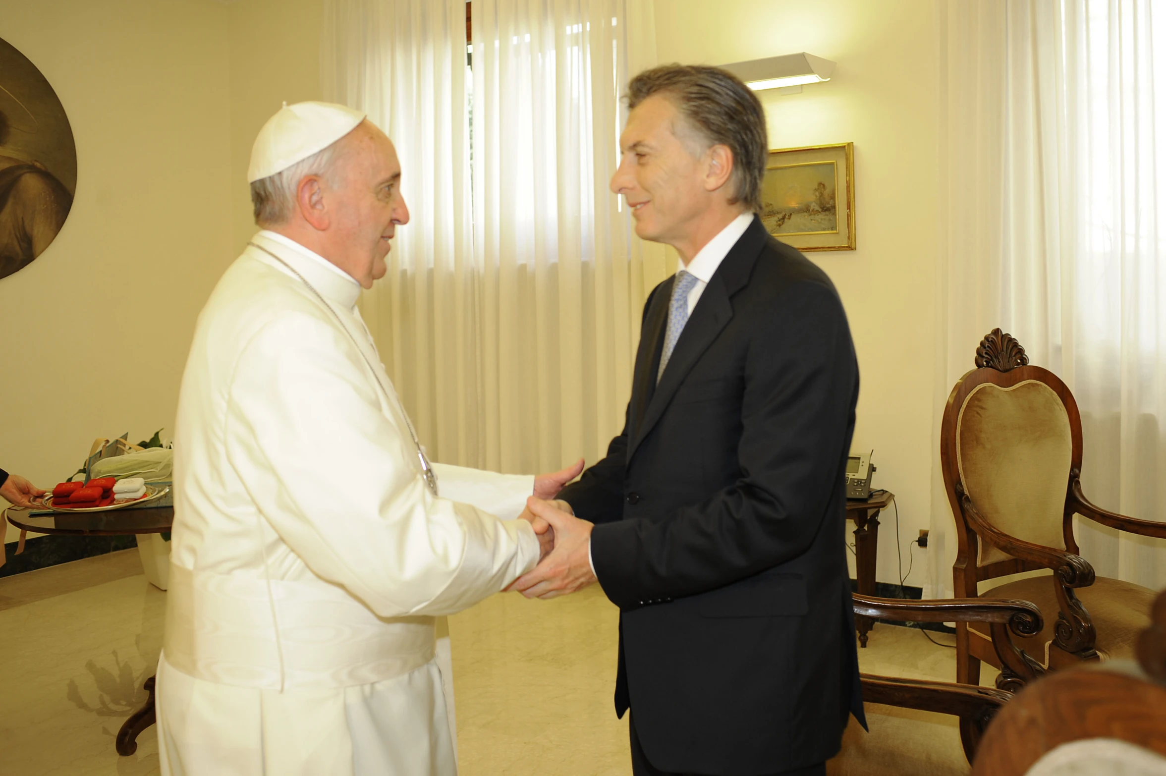 two men in suits shaking hands with one another