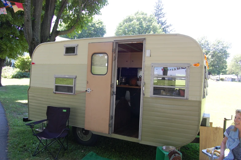 a woman and her small trailer in the grass