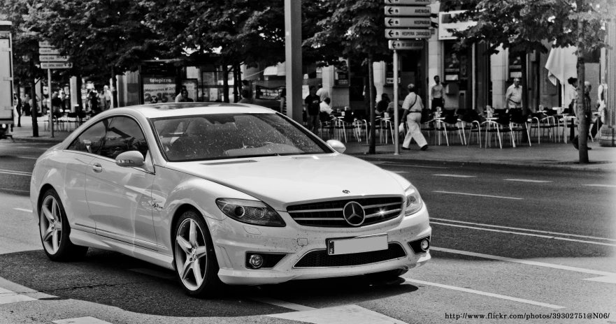 black and white pograph of a mercedes c - class car driving down the road