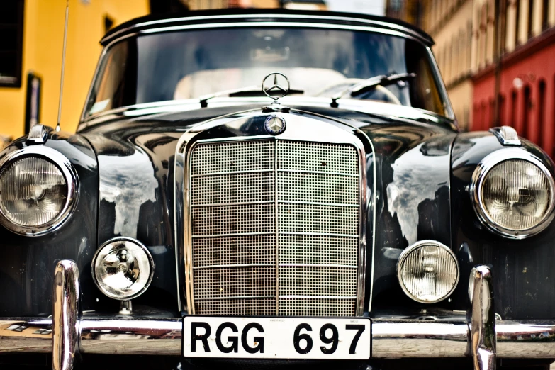 a vintage car front view sitting outside of a building