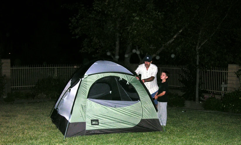 two men standing near a tent and gate