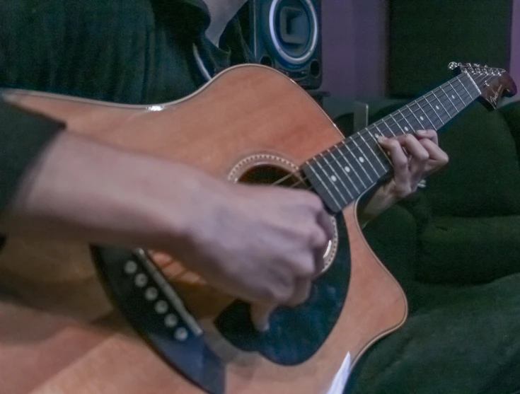 someone playing the guitar while they are in the chair