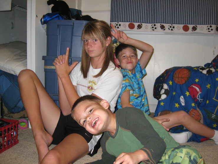 some young children sitting on the floor posing for the camera