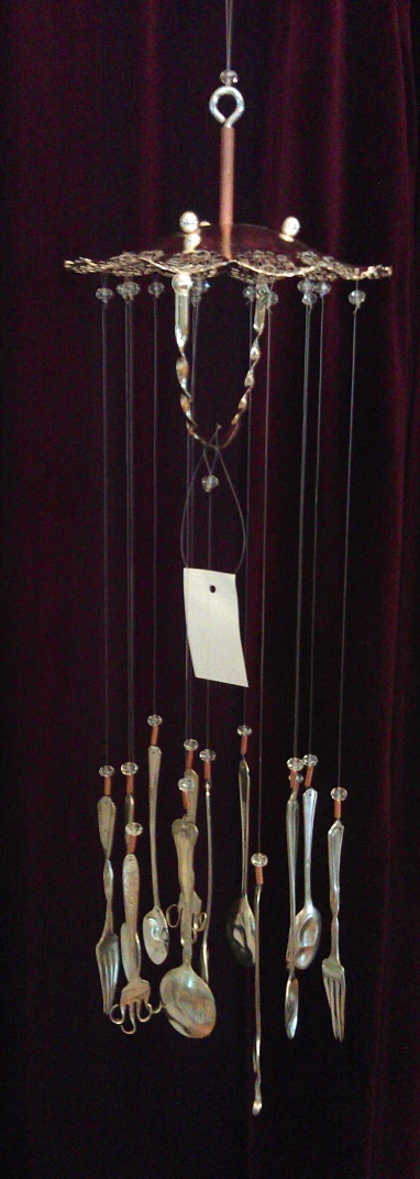 a sculpture of spoons hanging from a curtain