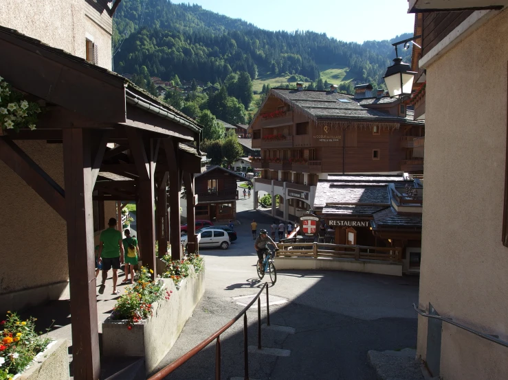 a man on a bicycle rides in a narrow alley way