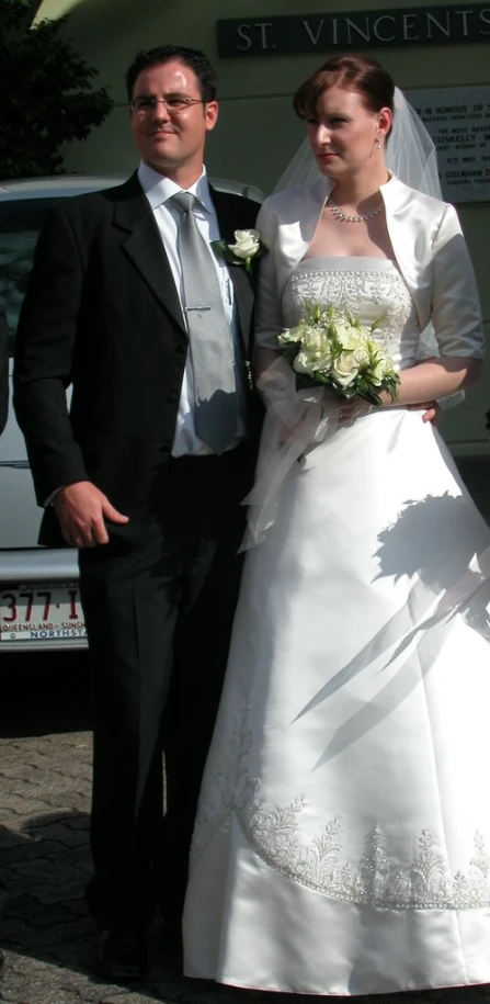 man and woman dressed up in wedding clothes posing for a picture