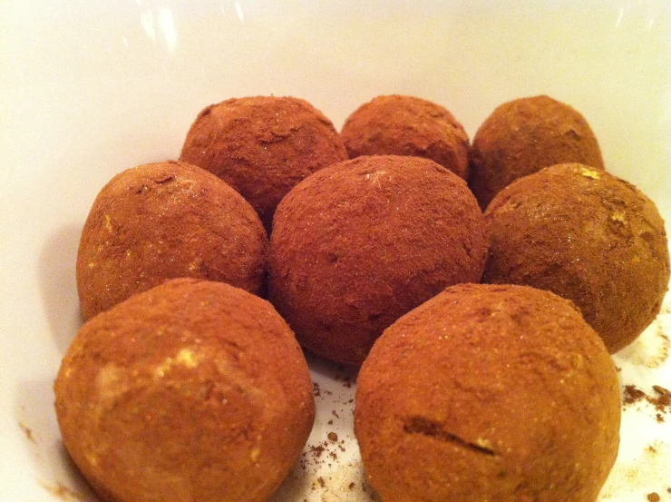 an open white bowl filled with six baked goods