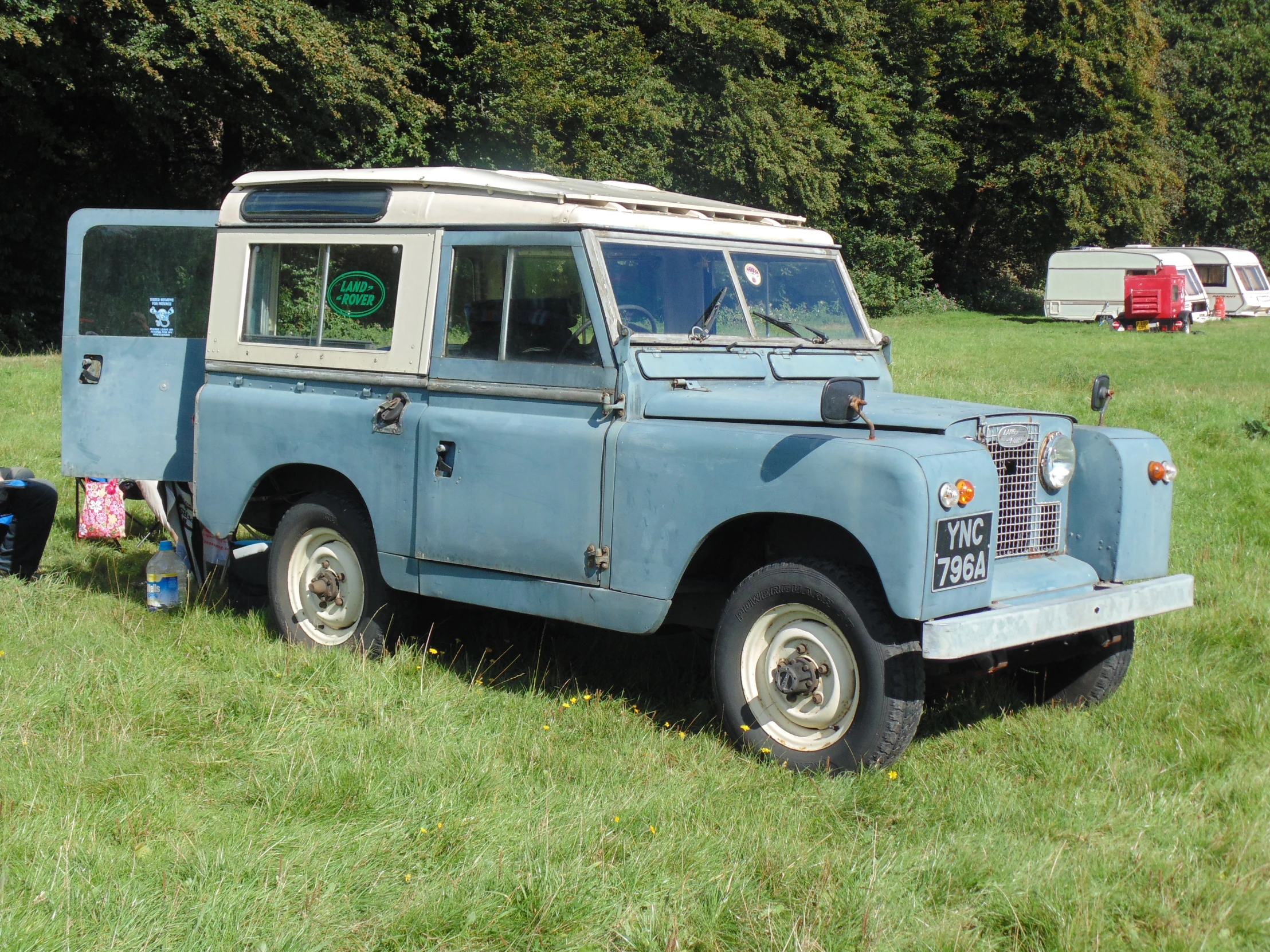 a vehicle that is blue in color sitting in the grass