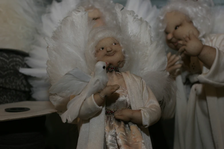 two statues of two angel dolls are shown with their hands touching each other