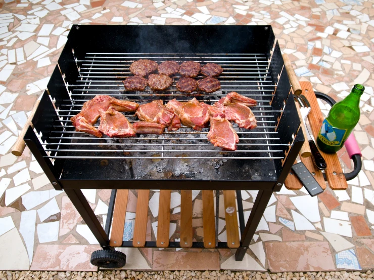 bbq grill with hamburger patties and  dogs cooking