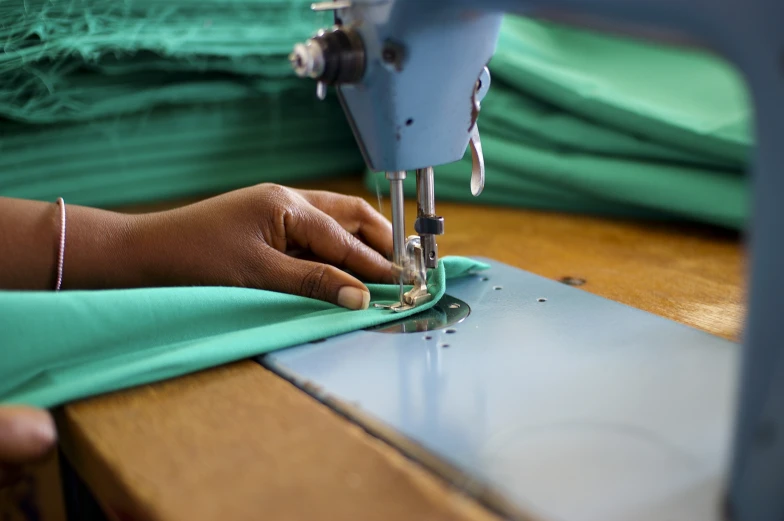 a woman using a sewing machine to sew fabric