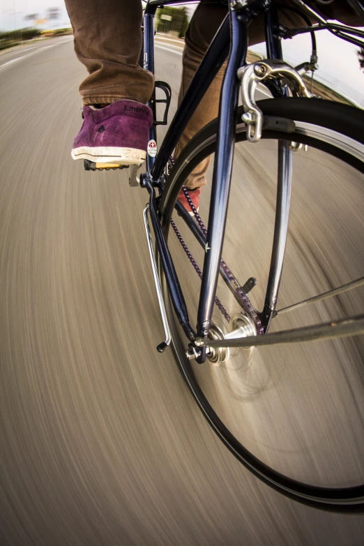 a person riding a bicycle on a street with blurry background