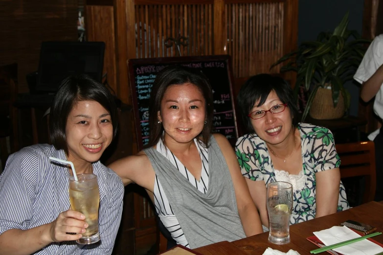 three women at a bar pose for the camera