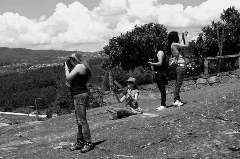 black and white pograph of people standing on hillside near trees