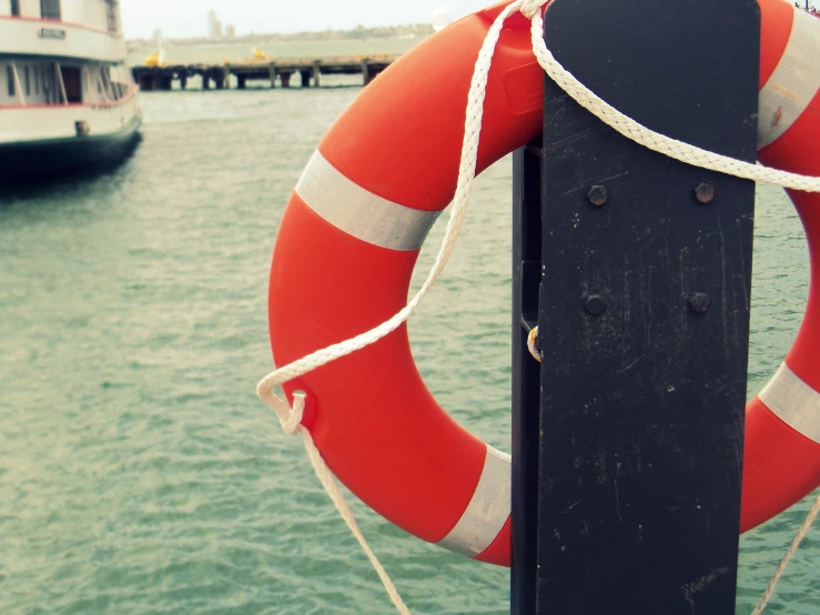 a black dock post with an orange and white life preserver on it