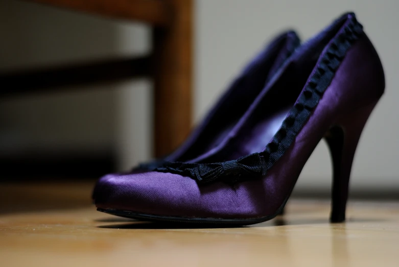 the purple shoes are decorated with black lace