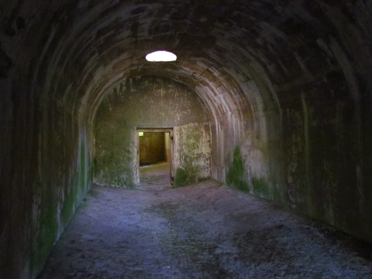 an old stone tunnel with a door in the end