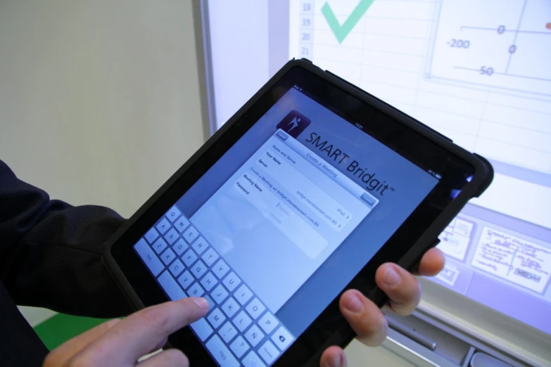 a man holds up an electronic device with a keyboard on it