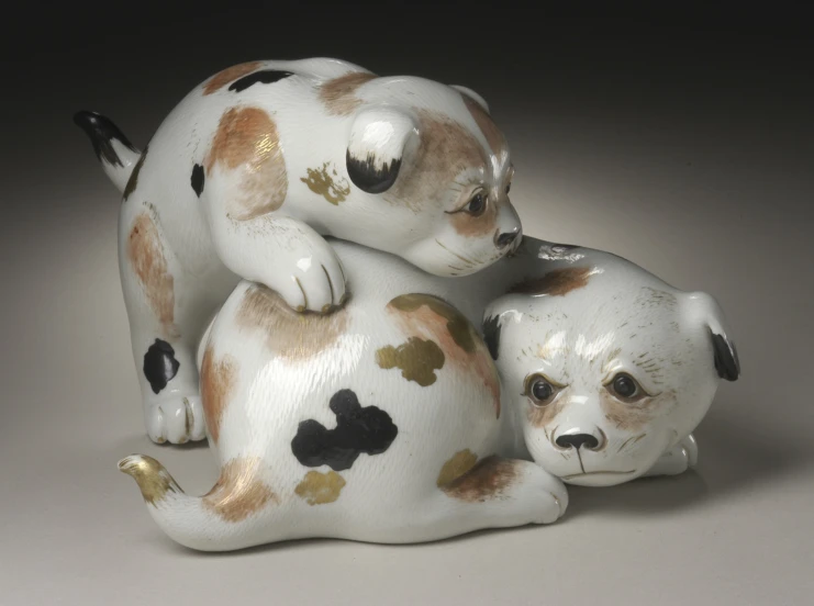 two white and brown ceramic dogs on grey background