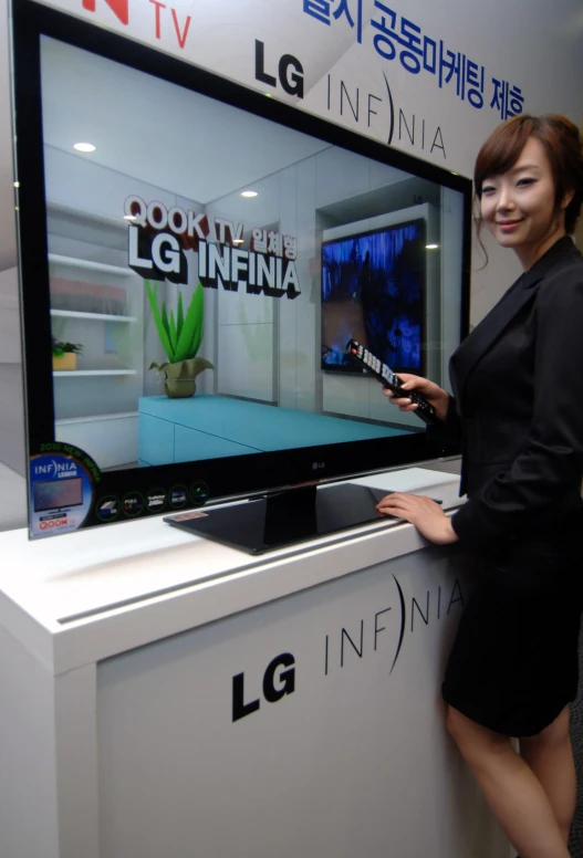 a woman is standing next to a large television