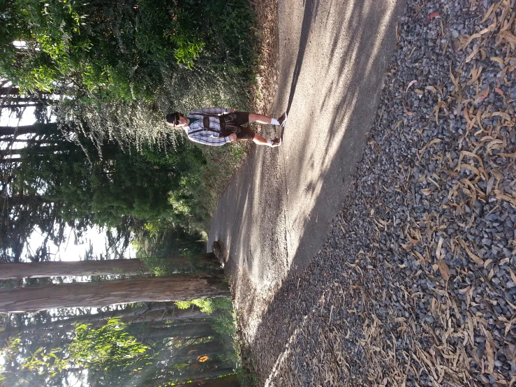 the man is running down the dirt trail in a park