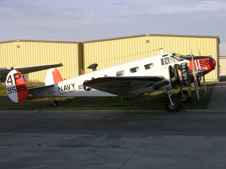 a black and white plane parked next to a hangar