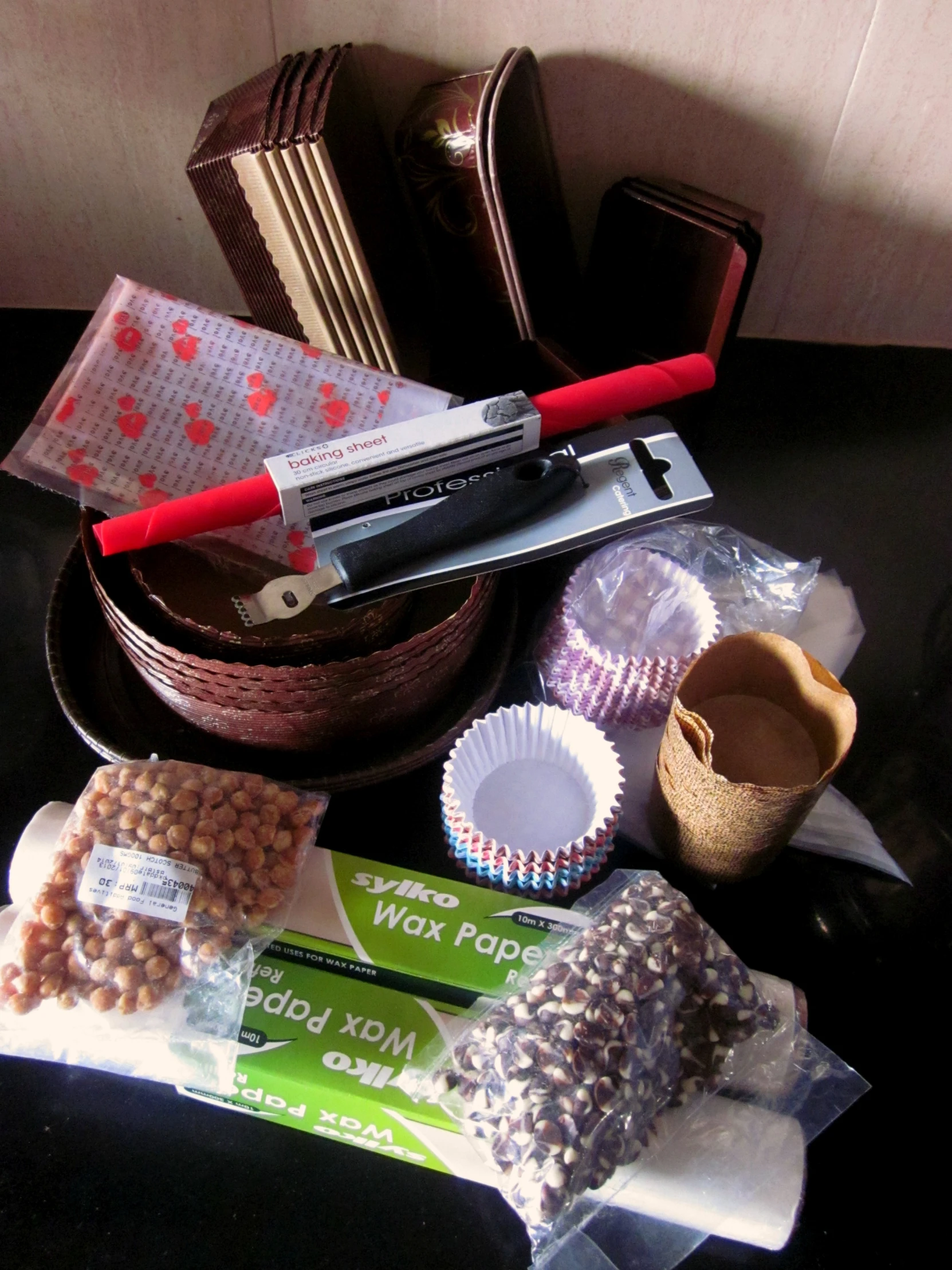 a pair of red handled scissors is on a table, with many different items surrounding it