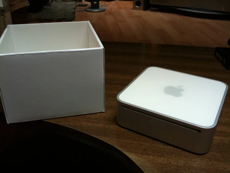an apple product sitting on a table next to an empty box