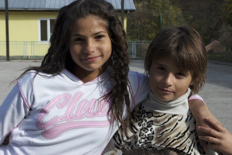 two children are smiling at the camera