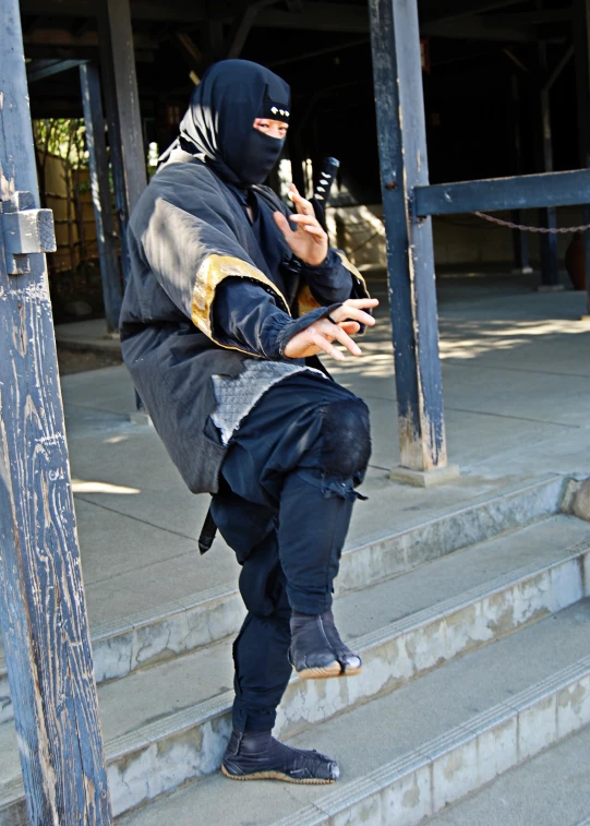 a person with a mask holding soing while standing on some stairs