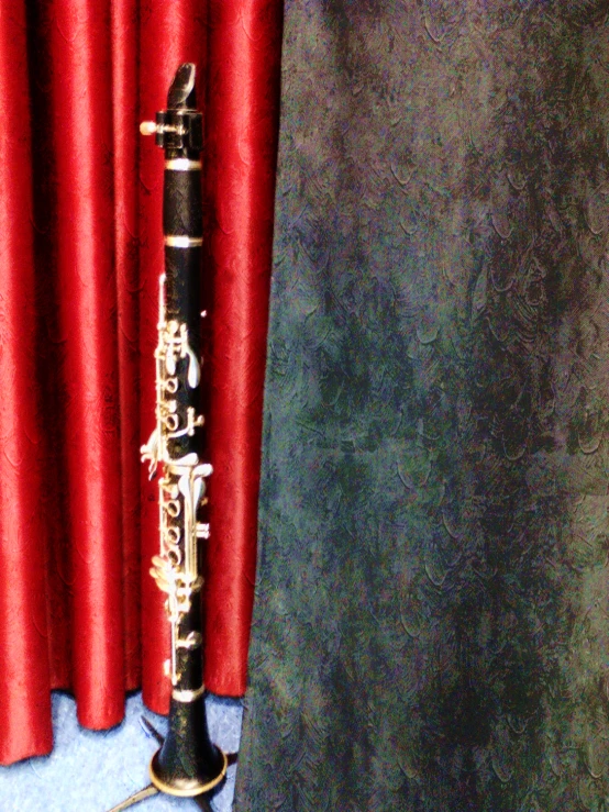 a black pipe is on display next to a red curtain