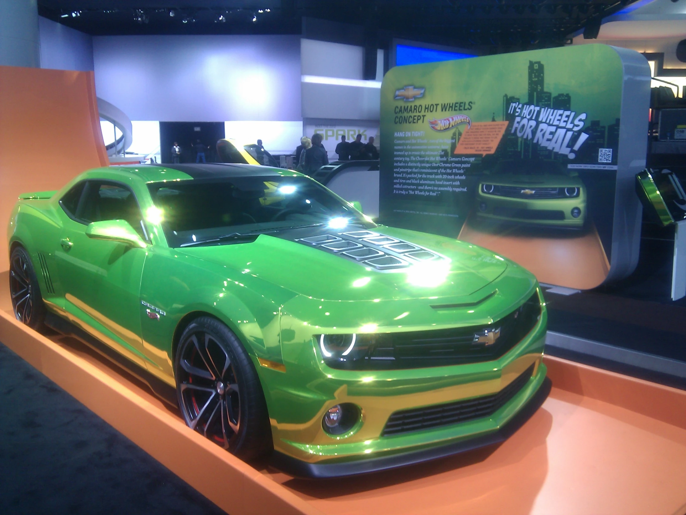 a green sports car with chrome accents on display