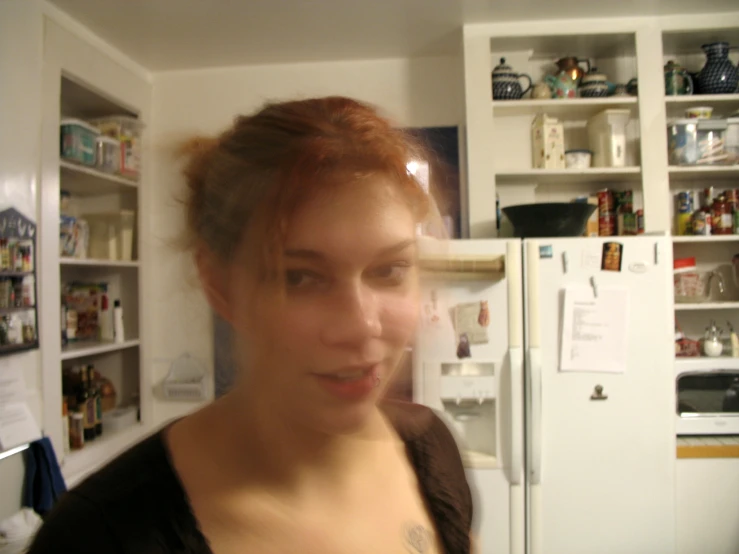 a close - up of a woman's face in front of a refrigerator