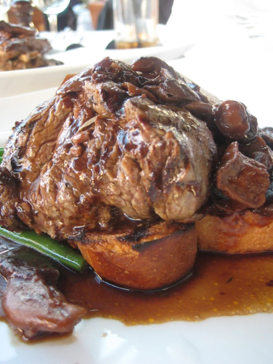 steak served with green beans and sauce on white plate