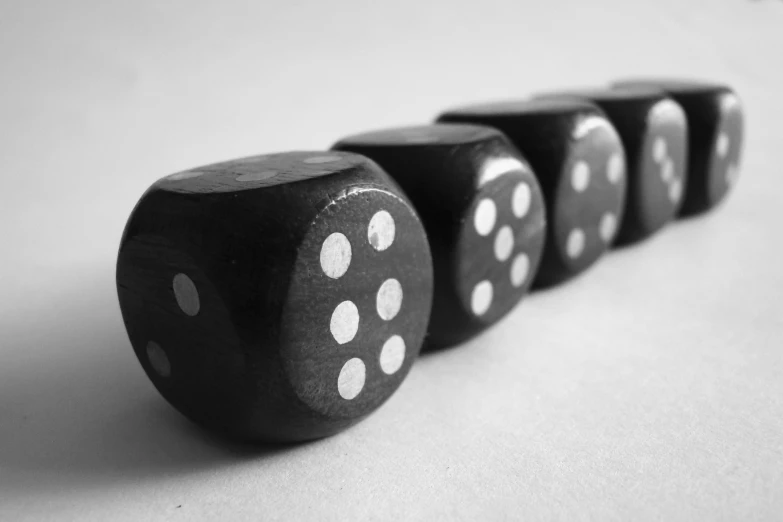 four dice sitting side by side in black and white