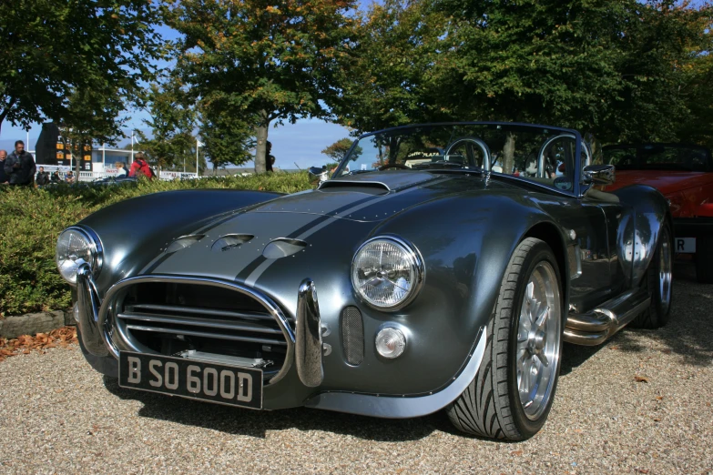 a black vintage sports car parked in a lot