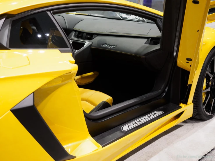 the door of a yellow sports car on display