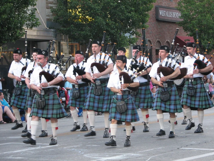 a group of men in kilts marching down the street