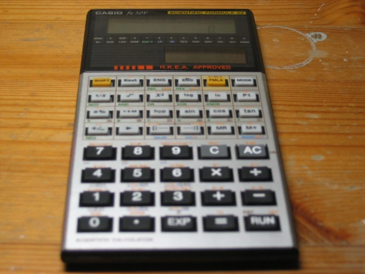 this is a calculator lying on top of a wooden table