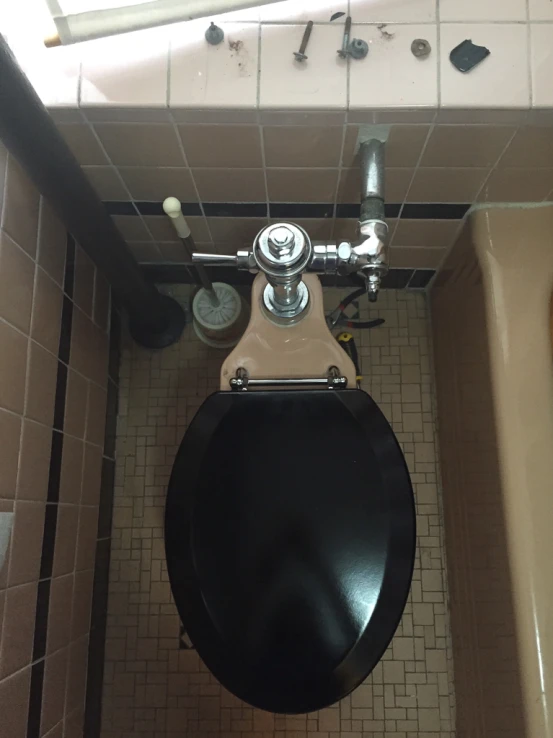 a black toilet in a bathroom next to a bathtub
