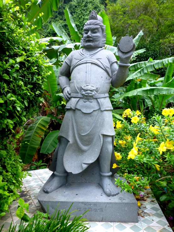 an outdoor statue holding a leaf in its right hand