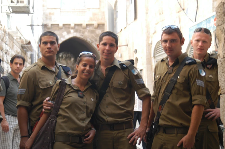 several men and a woman posing for a po in military fatigues