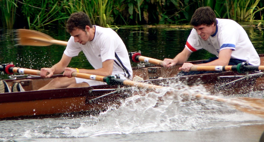 two men riding in canoes down a river