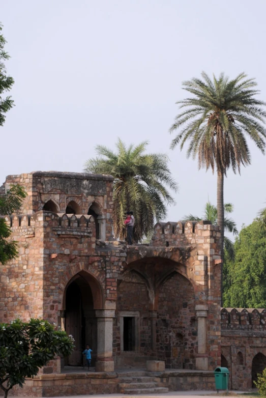 an old building with palm trees on either side