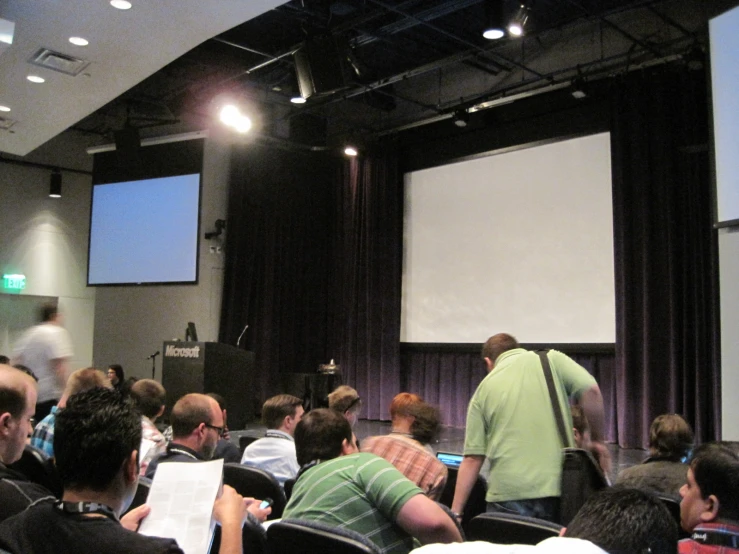 several people are watching a projection on a screen