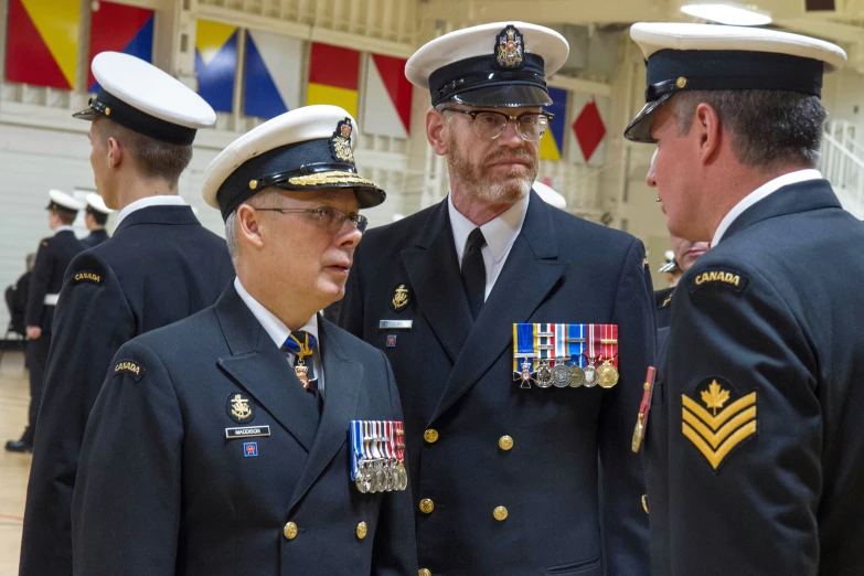 four men in military uniforms standing around each other