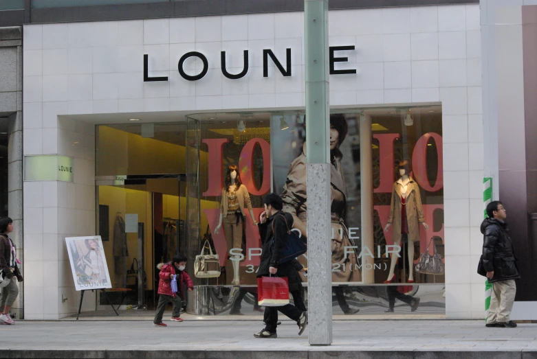 a store front with people walking by and shopping bags