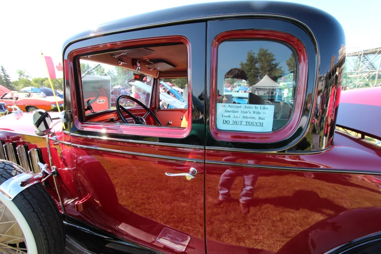 the back window of a old red car is showing signs for sale