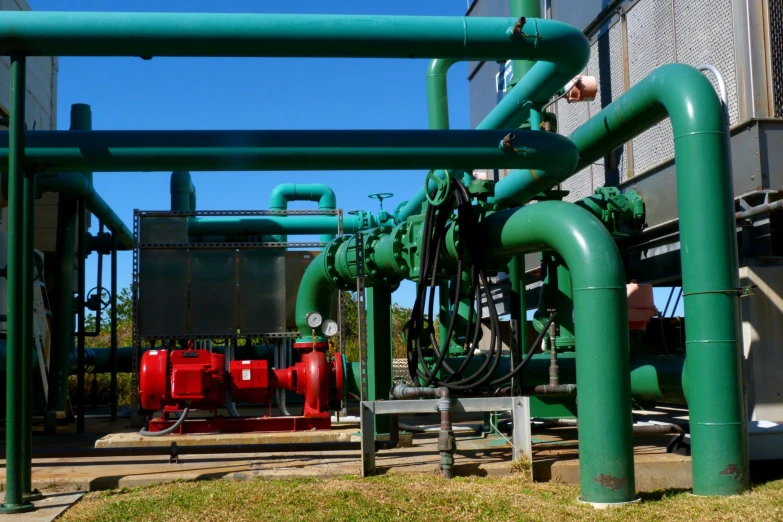 some metal pipes with red and green containers behind them
